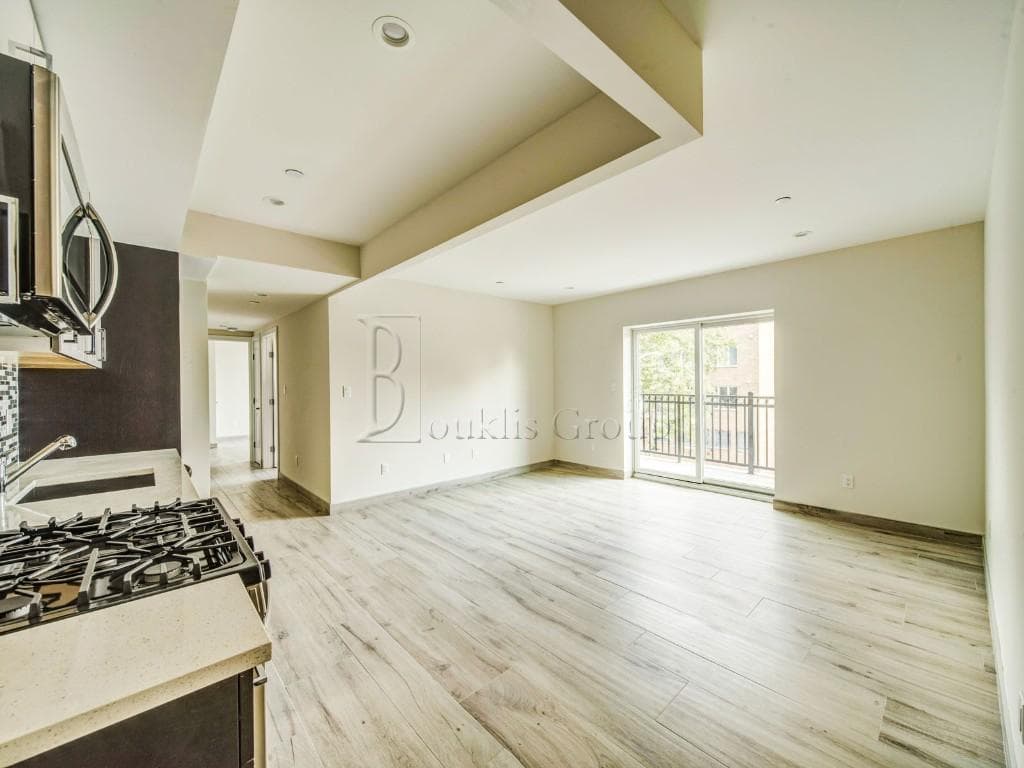 Luxury high-rise apartment interior with open living space and balcony — The Bouklis Group